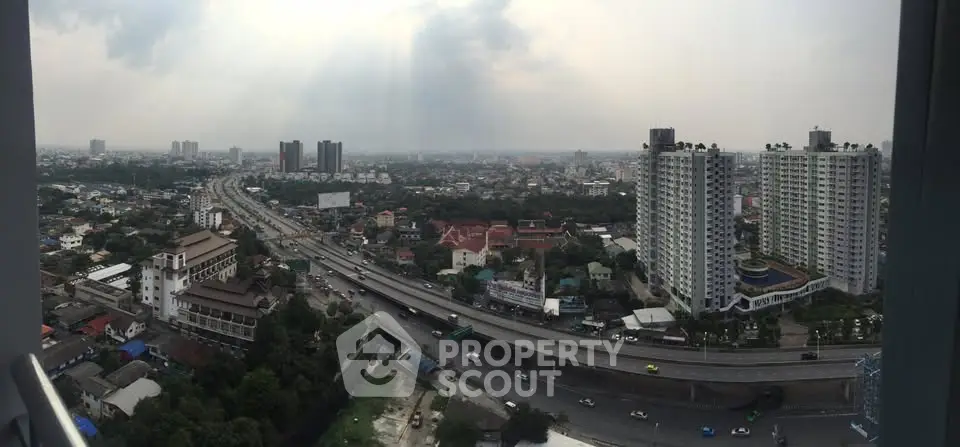 Panoramic cityscape view with high-rise buildings and highway, showcasing urban living and infrastructure.