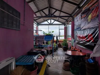 Spacious covered balcony with laundry area and city view, perfect for urban living.