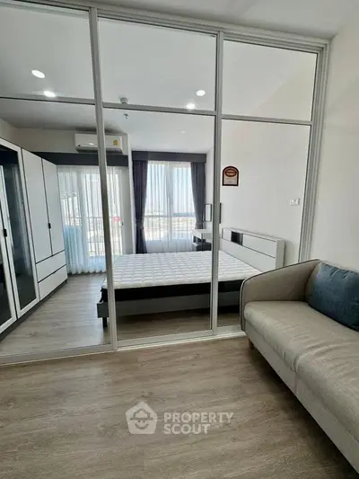 Modern bedroom with glass partition, stylish furniture, and natural light in a contemporary apartment.