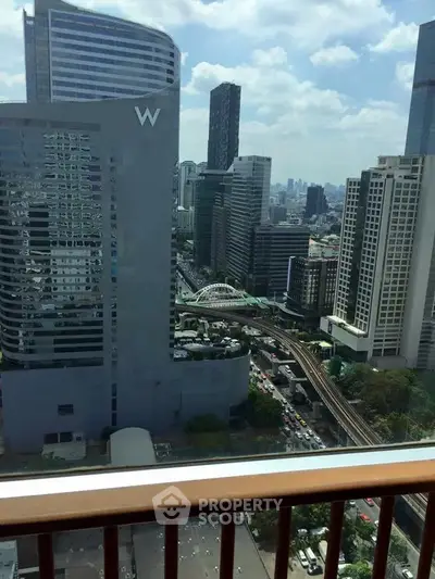 Stunning cityscape view from a high-rise balcony overlooking urban skyline and bustling streets.