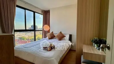 Cozy bedroom with large window offering stunning city view, modern decor, and ample natural light.