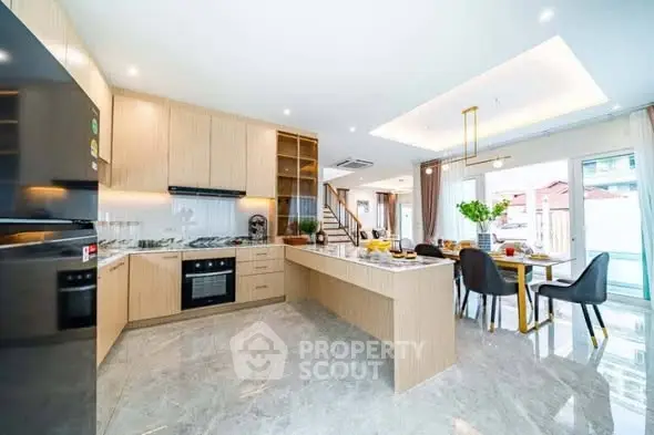 Spacious modern kitchen with open layout and dining area, featuring sleek appliances and elegant decor.