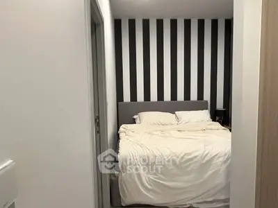 Cozy bedroom with striped accent wall and plush bedding