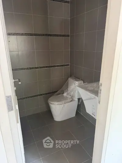 Modern bathroom with sleek gray tiles and new fixtures, perfect for contemporary living.