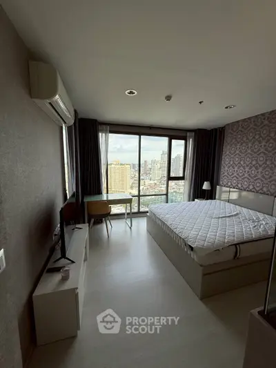Spacious bedroom with city view, modern decor, and large windows for natural light.