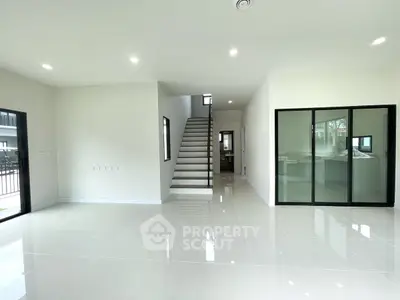 Spacious modern living room with sleek staircase and large windows