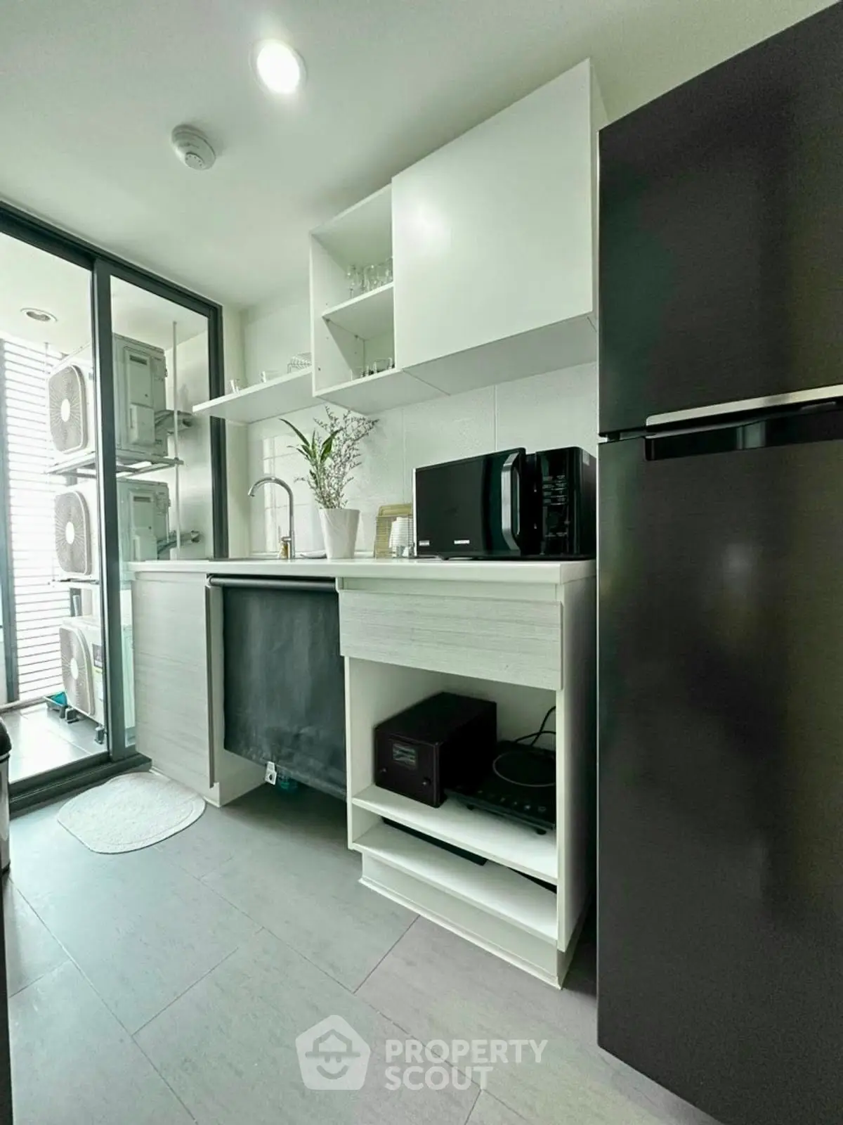 Modern kitchen with sleek appliances and open shelving in a compact layout.