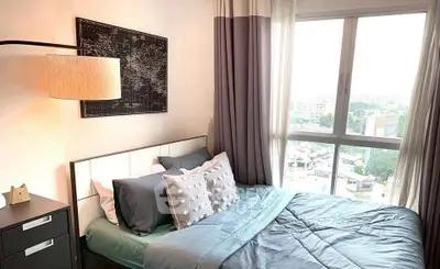 Cozy bedroom with large window offering stunning city views, modern decor, and ample natural light.