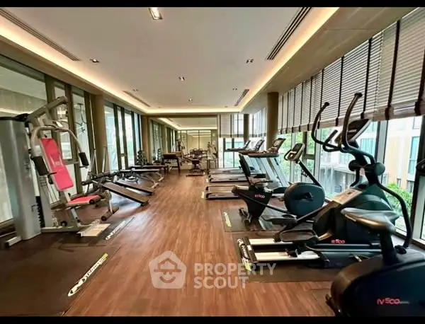 Modern gym with state-of-the-art equipment and large windows for natural light.