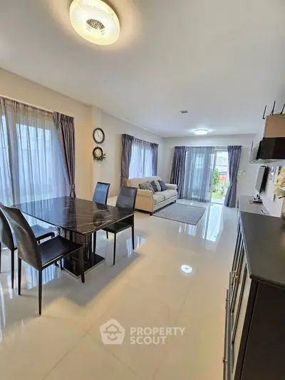 Spacious modern living room with elegant dining area and large windows for natural light.