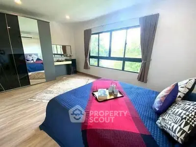Spacious bedroom with large window and modern decor