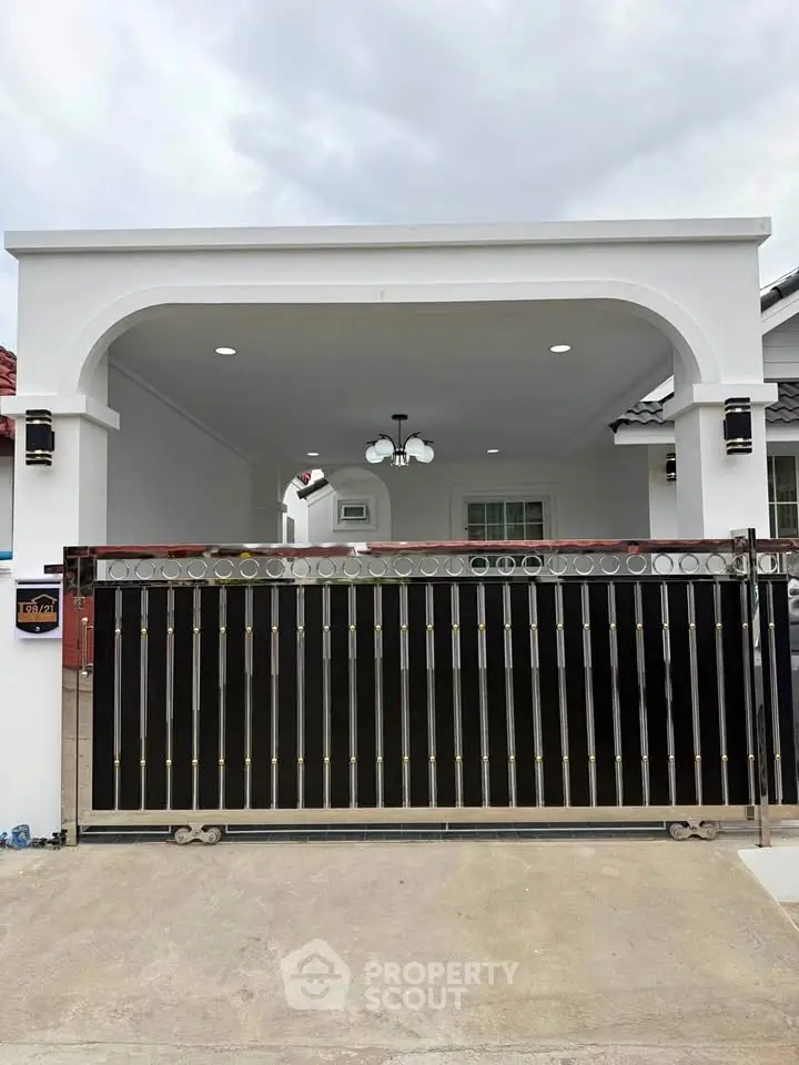 Charming single-story home with elegant gated entrance and modern exterior design.