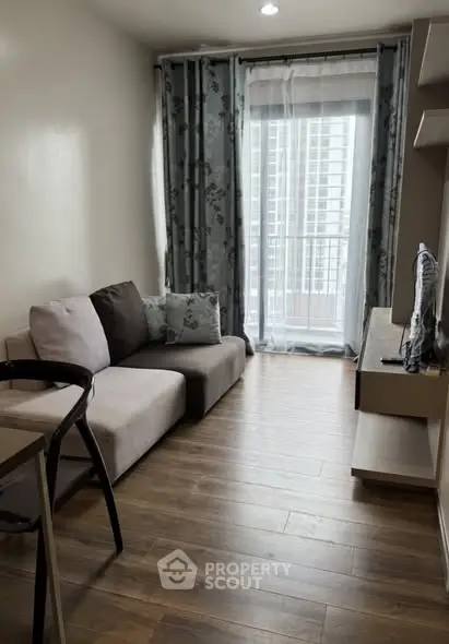 Cozy living room with modern decor and large window offering city view.