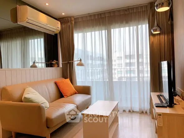 Modern living room with cozy sofa and large window, perfect for relaxation.