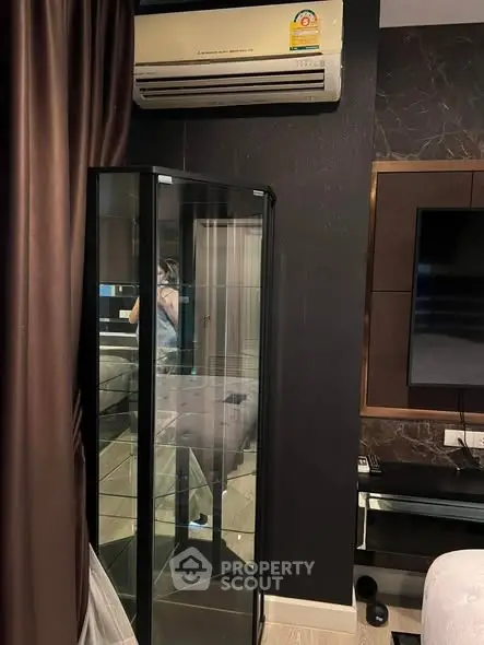 Modern living room with air conditioning and sleek glass cabinet