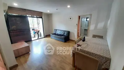 Spacious living room with wooden flooring and balcony access in modern apartment.