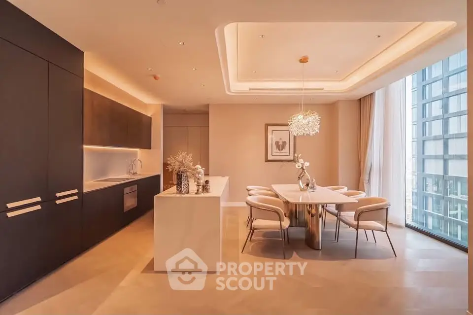 Luxurious modern kitchen and dining area with elegant lighting and large windows.