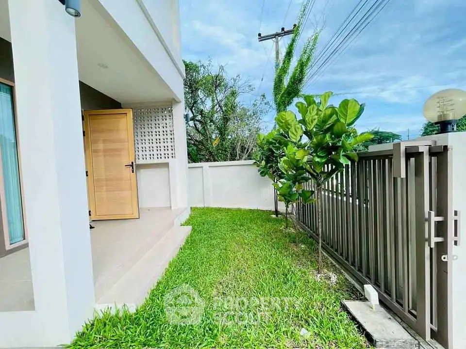 Charming modern home entrance with lush green garden and secure gate