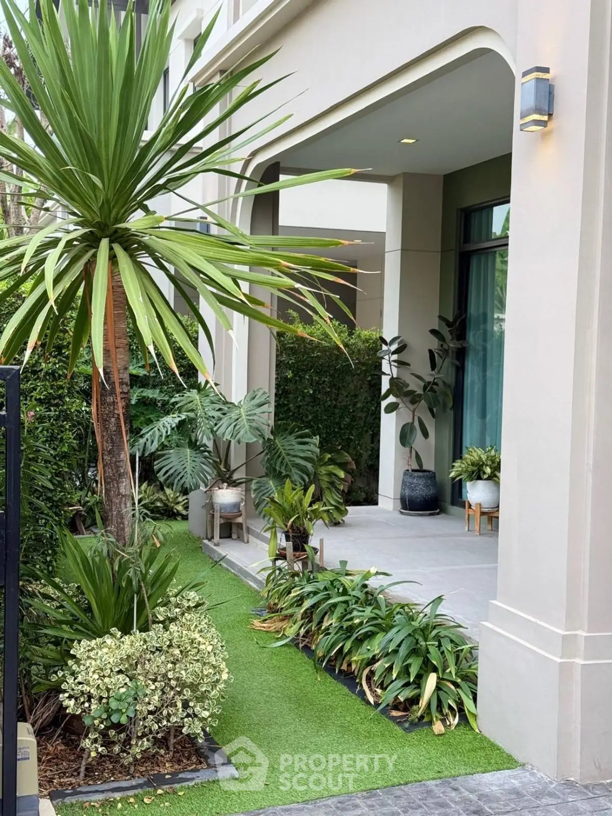 Elegant garden entrance with lush greenery and modern architecture