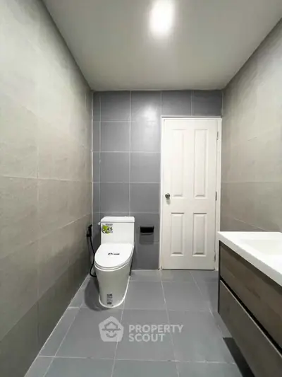 Modern bathroom with sleek gray tiles and contemporary fixtures.
