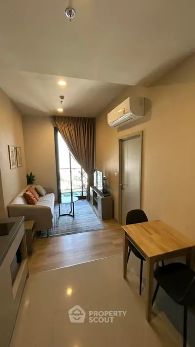 Modern living room with cozy sofa, dining table, and balcony view in stylish apartment.