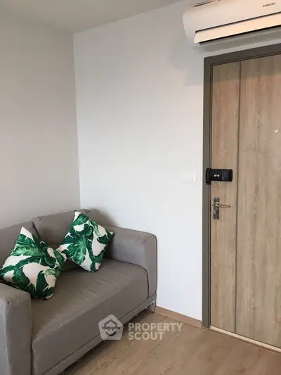 Modern apartment entrance with cozy sofa and tropical decor pillows