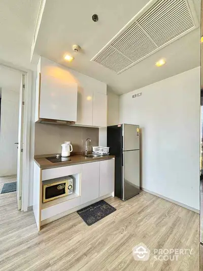 Modern kitchen with sleek cabinetry and stainless steel appliances in a stylish apartment.