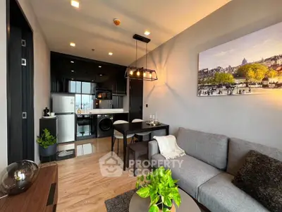 Modern living room with open kitchen, stylish decor, and natural light in a contemporary apartment.