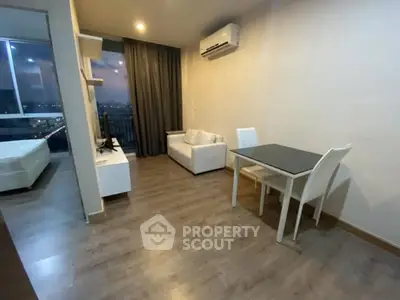 Modern apartment interior with living room and dining area, featuring sleek furniture and a city view.