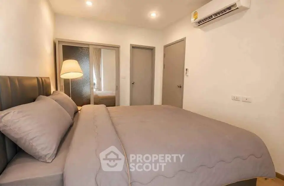 Cozy bedroom with modern decor and soft lighting, featuring a comfortable bed and mirrored closet doors.