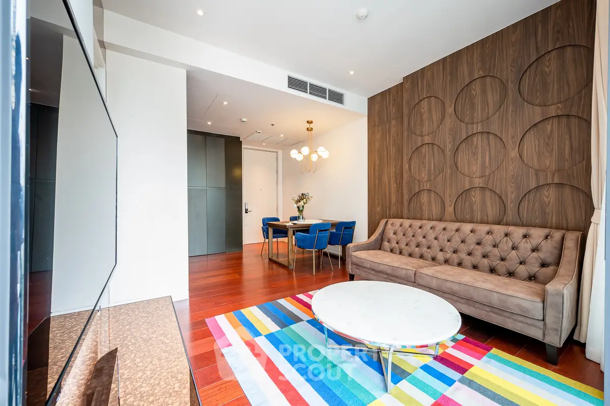 Modern living room with stylish decor, colorful rug, and elegant furniture in a contemporary apartment.