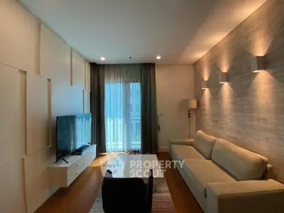 Modern living room with stylish decor and large TV, featuring cozy sofa and elegant lighting.