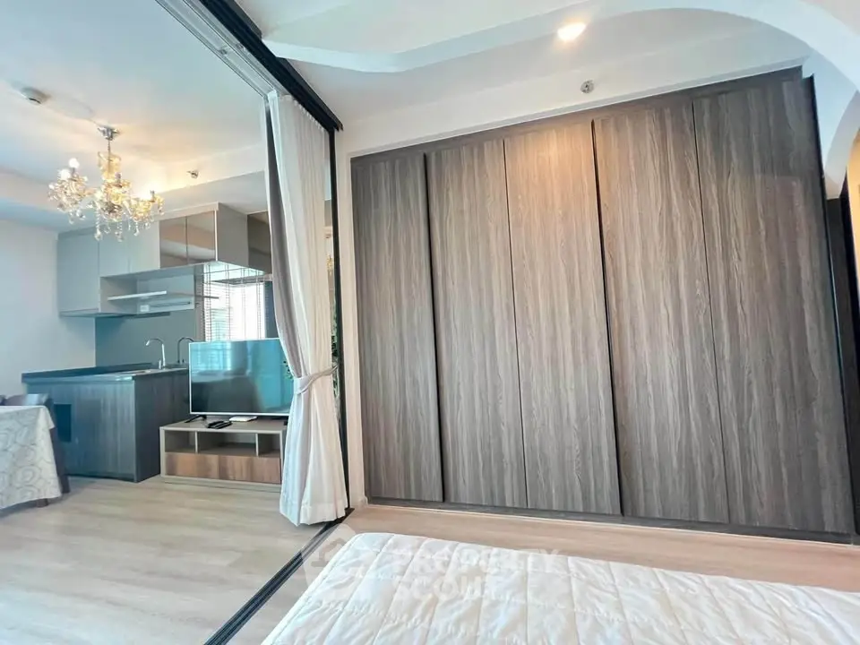 Modern studio apartment with open layout, featuring a sleek kitchen and spacious wardrobe.