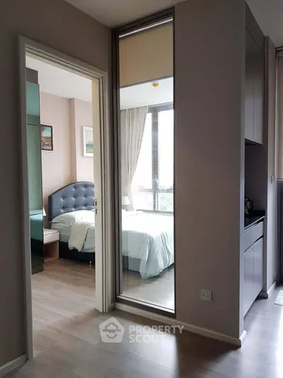 Modern apartment interior with bedroom and hallway view, featuring sleek design and natural light.