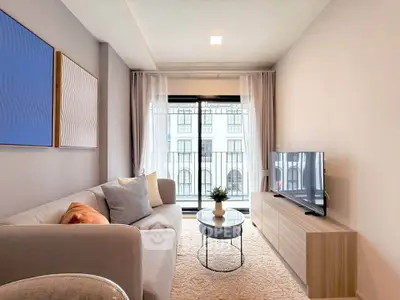 Modern living room with stylish decor and large window offering natural light.