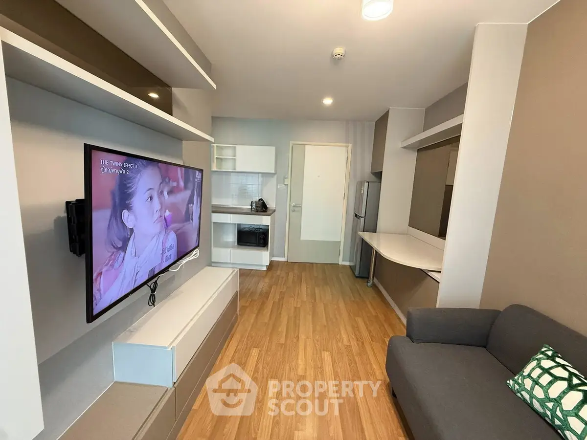 Modern living room with sleek furniture and wall-mounted TV in a stylish apartment.