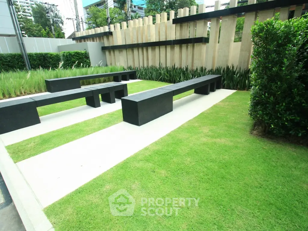 Modern garden area with sleek benches and lush greenery, perfect for relaxation and outdoor gatherings.