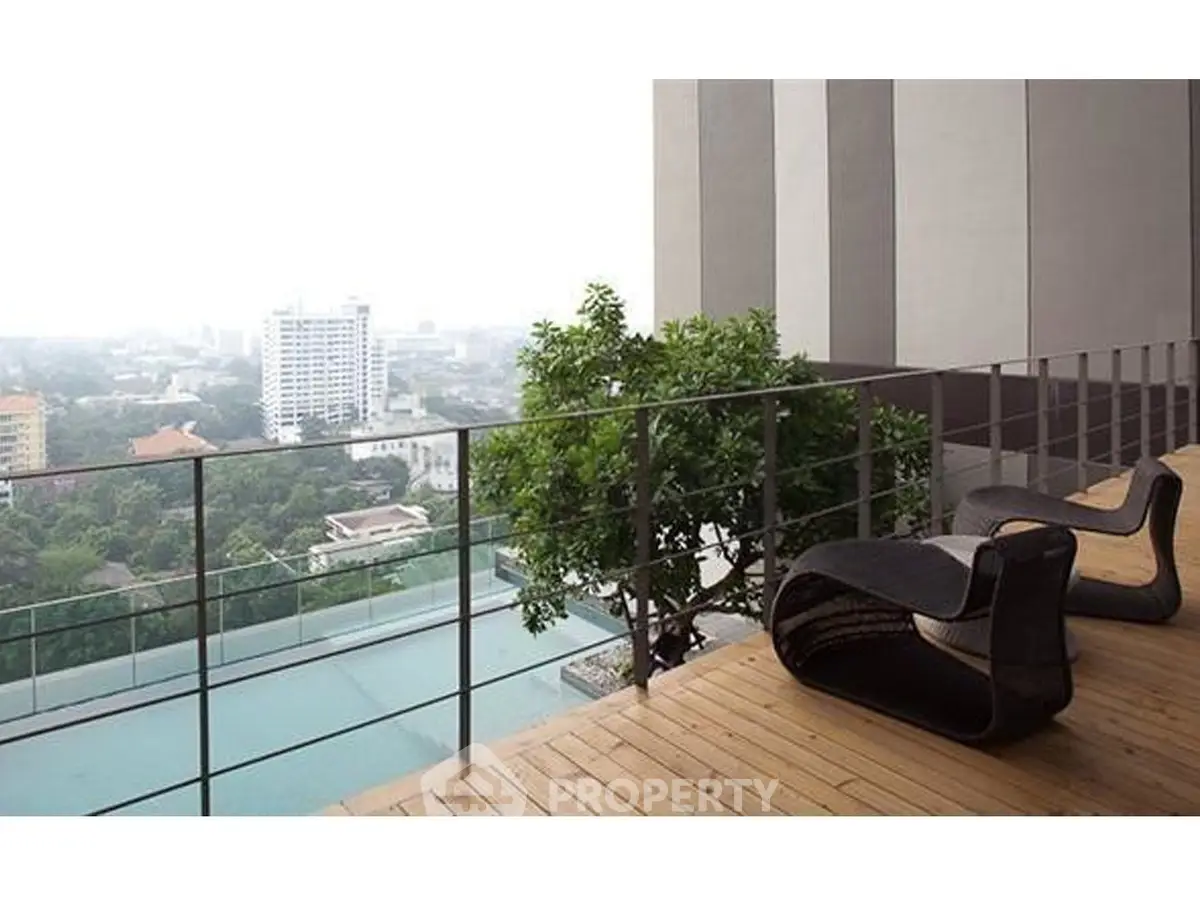 Stunning balcony with panoramic city view and modern seating, perfect for relaxation.