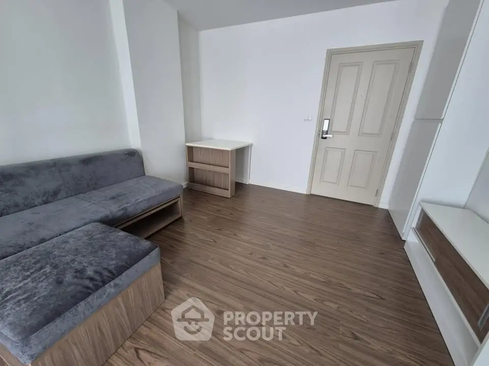 Modern living room with sleek wooden flooring and minimalist furniture