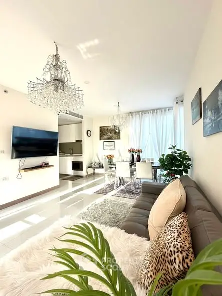 Luxurious living room with elegant chandelier and modern decor in a bright, open layout.