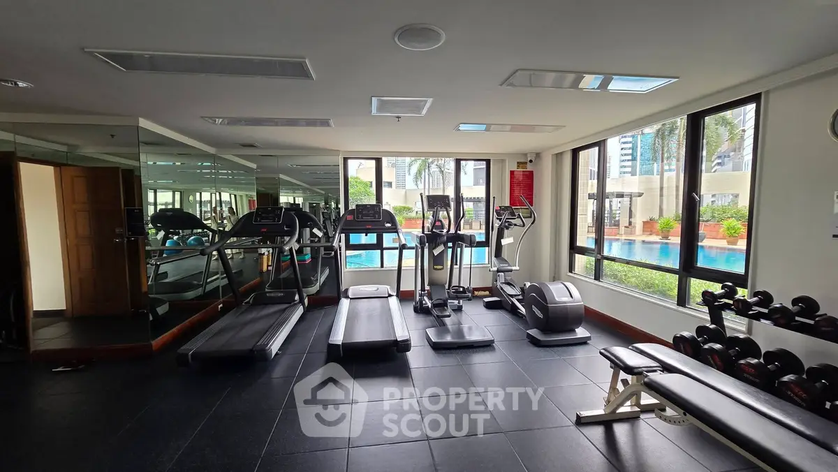 Modern gym with pool view in luxury apartment building