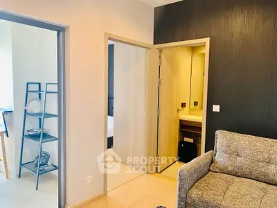 Modern apartment interior with cozy living room and open doorway to bedroom and bathroom.