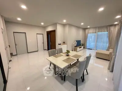 Spacious modern living room with elegant dining area and large windows for natural light.