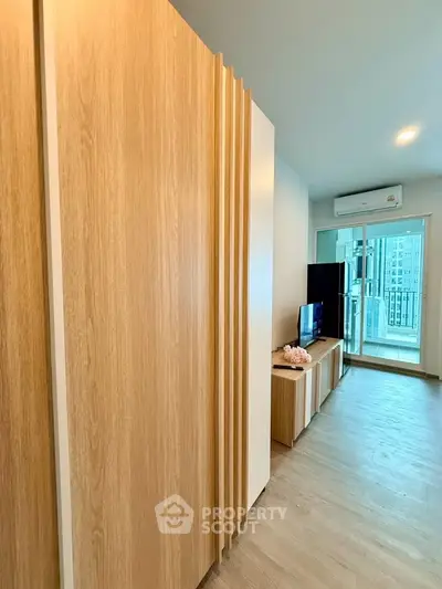 Modern living room with wooden accents and balcony view in a stylish apartment.