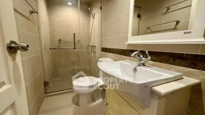 Modern bathroom with glass shower and sleek fixtures in a stylish real estate property.