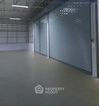 Spacious industrial warehouse with large roller doors and high ceiling