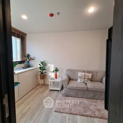 Cozy living room with stylish decor and natural light, featuring a comfortable sofa and indoor plants.