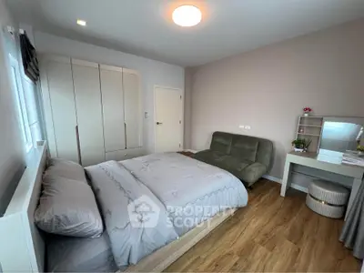 Spacious bedroom with modern decor and cozy seating area