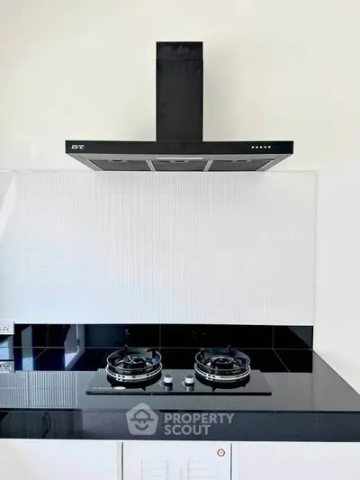 Modern kitchen with sleek black gas stove and elegant range hood