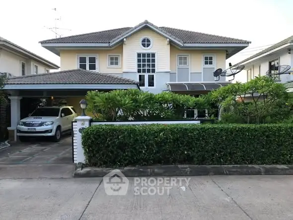 Charming two-story house with lush greenery and spacious driveway in a serene neighborhood.